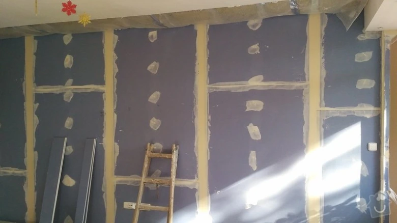 Stěna s nainstalovanými deskami z sádrokartonu na dřevěných trámech.