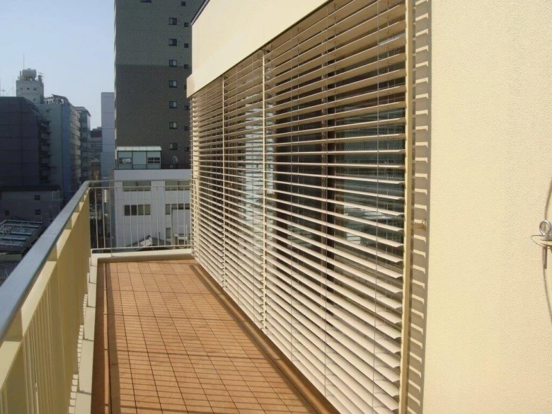 Venkovní žaluzie na balkóně v městském prostředí.