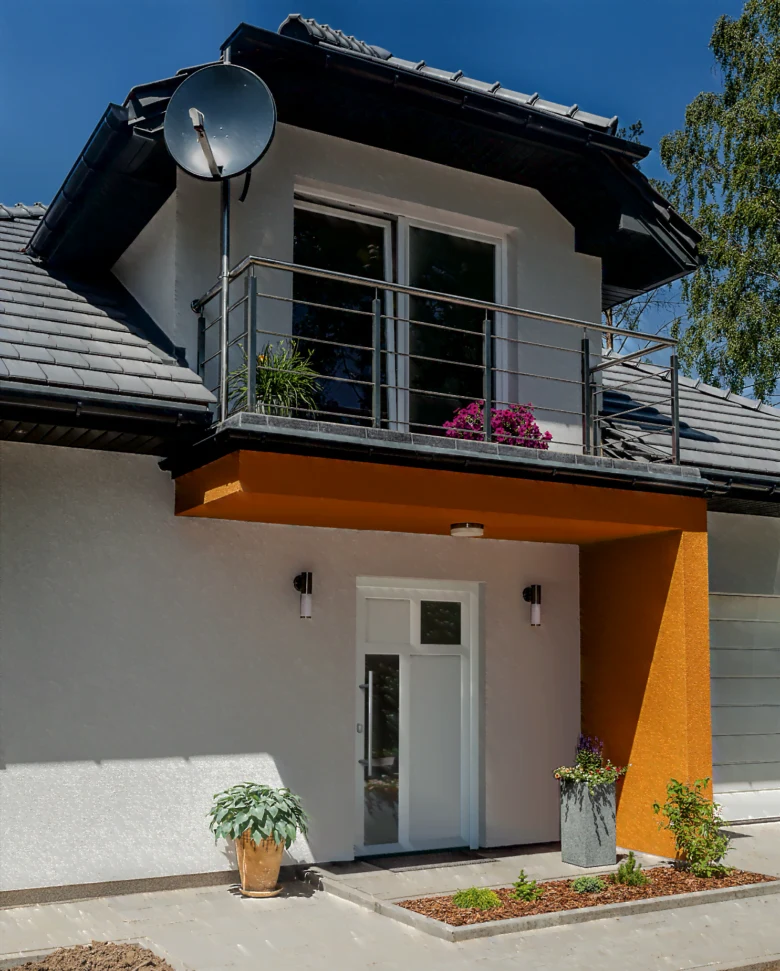 Moderní venkovní dveře s výhledem na balkon u domu.
