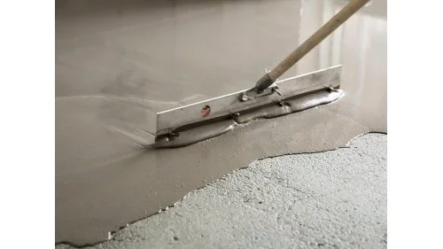 Nástroj pro rozprostírání samonivelační stěrky na podlaze.