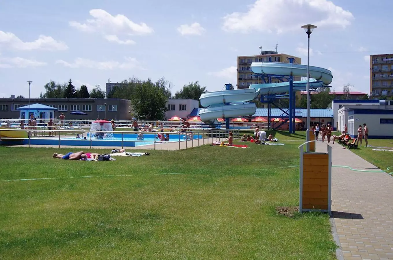 Venkovní bazén s vodními skluzavkami v koupališti pro plavání.
