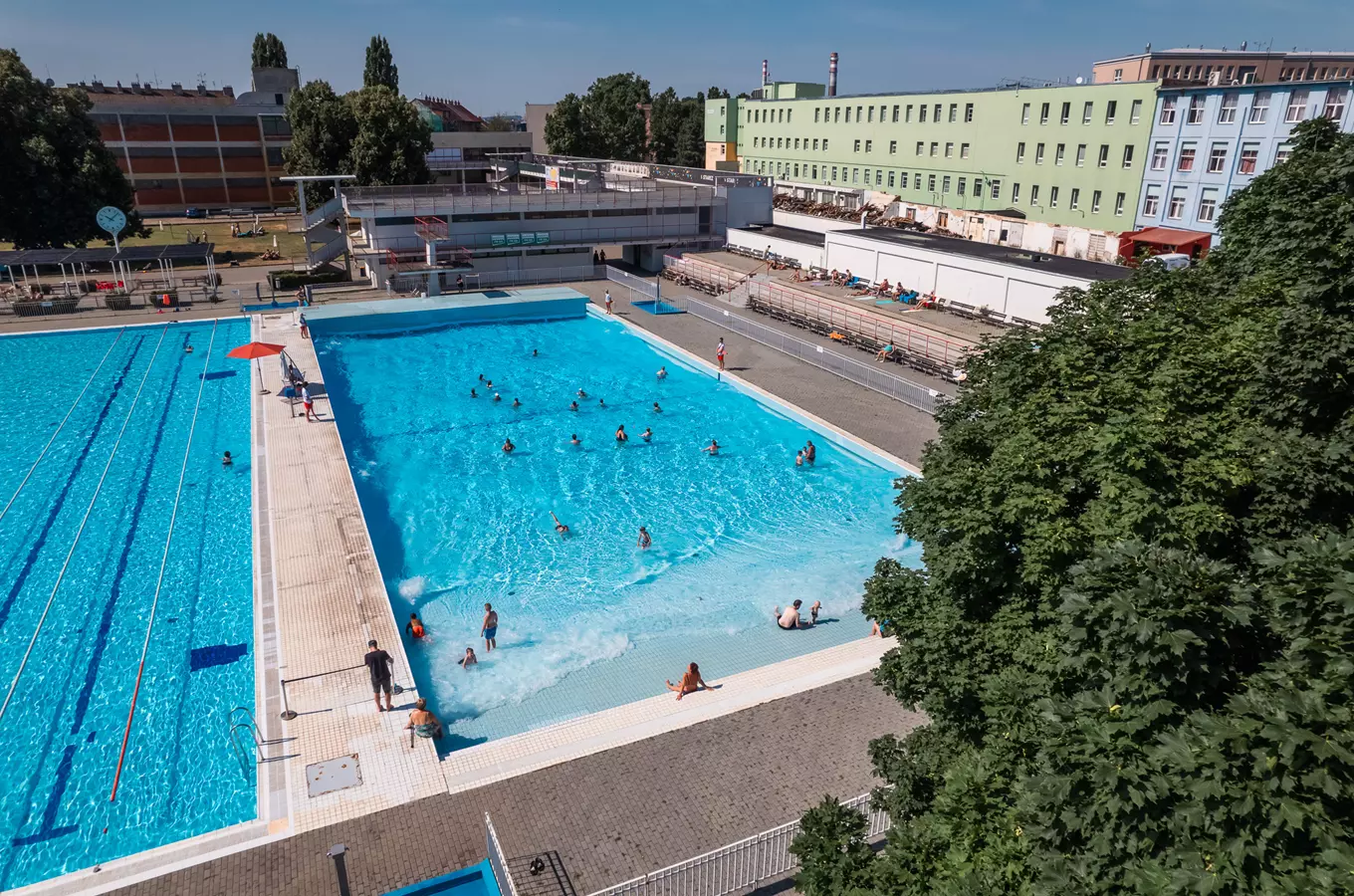 Venkovní plavecký bazén v Zábrdovicích s lidmi ve vodě.