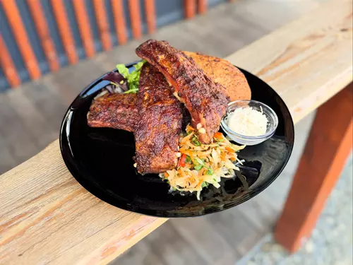 Pork ribs s grilováním se zelovou salátem na dřevěném stole.