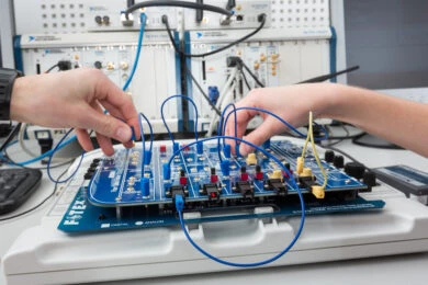 Ruční propojování elektronického modulu pro řídicí systémy.