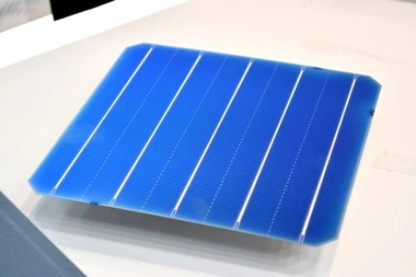 Modrá fotovoltaická buňka s viditelnými kontakty na bílém pozadí.