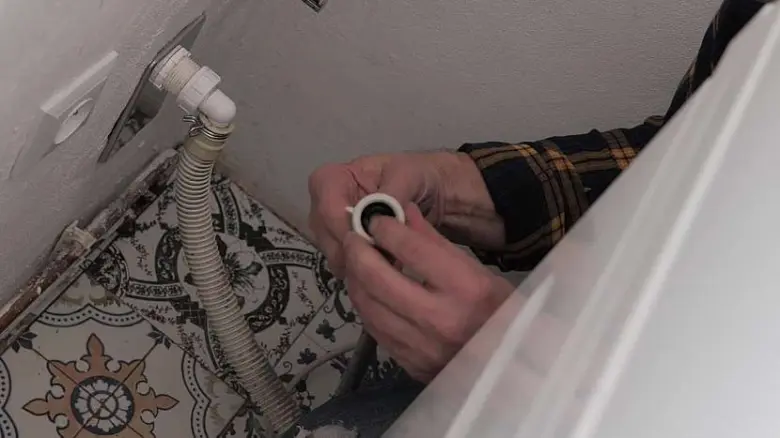Ruční připojení hadice pračky na odpadní otvor.