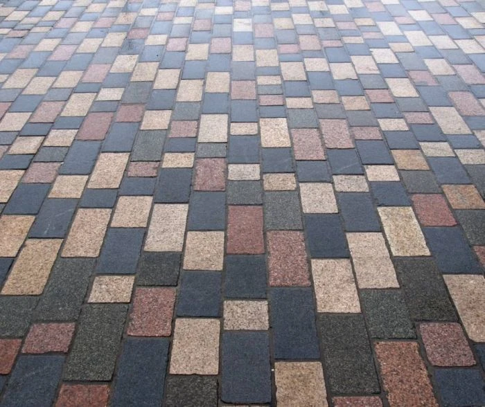 Zámková dlažba v barevném vzoru na chodníku ukazuje správnou skladbu.