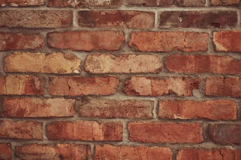 Zdivo z červených cihel s viditelnými spárami malt.