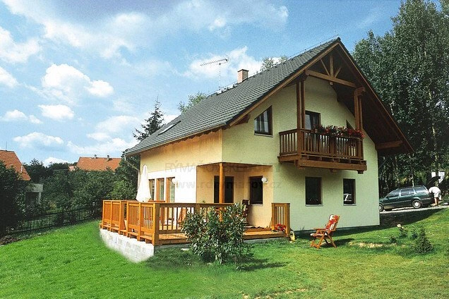 Dřevostavba na klíč s terasou a balkony v zeleném prostředí.