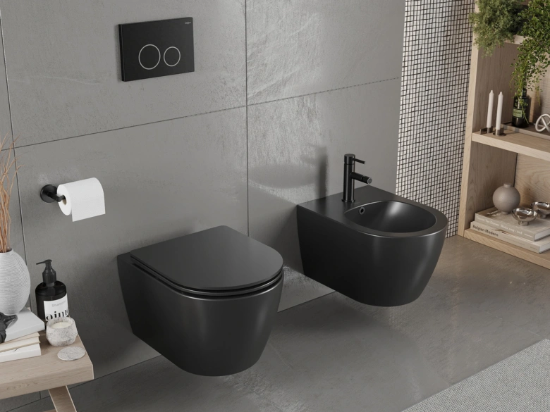 Černý nástěnný bidet vedle záchodu v šedé koupelně.