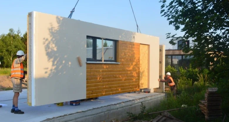 Montáž prefabrikované dřevostavby s pracovníky na stavbě.