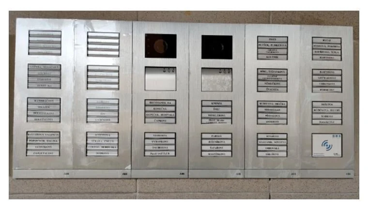 Panel s domovními zvonky a tlačítky pro volání do bytu.