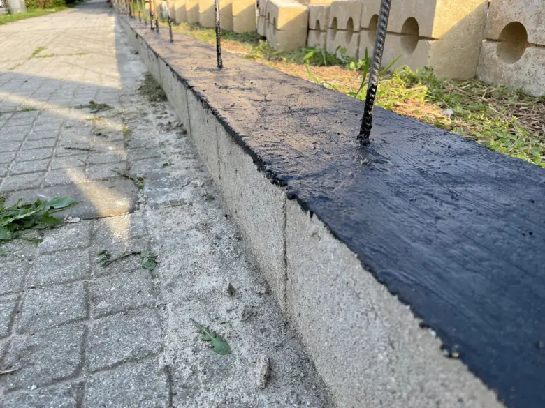 Tekutá hydroizolace na betonové zdi s výstužnou ocelí.