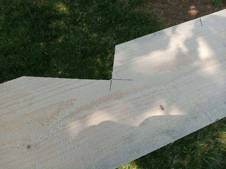 Dřevěná prkna s vyznačenými liniemi pro vyříznutí sedla krokve.