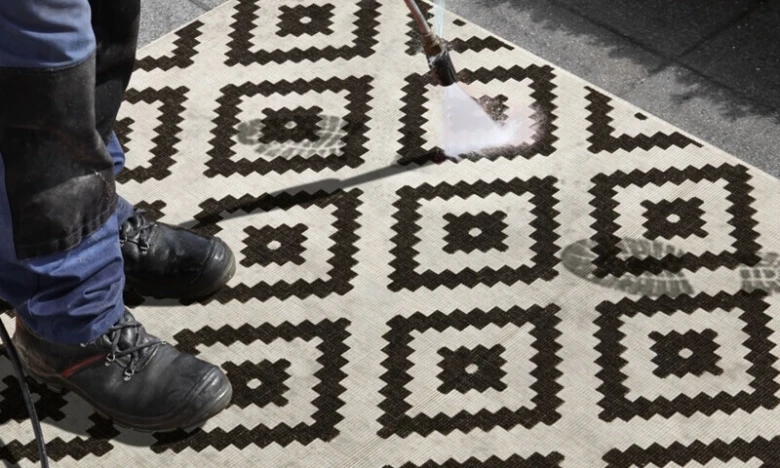 Čistění geometrického koberce na balkonu vysokotlakou vodou.
