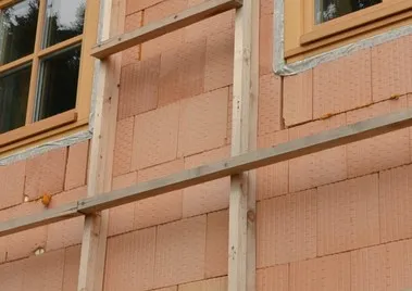 Konstrukce provětrávané fasády s nosným roštem a izolačními deskami.