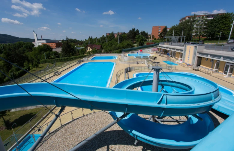 Modrý vodní tobogán nad bazénem v koupališti