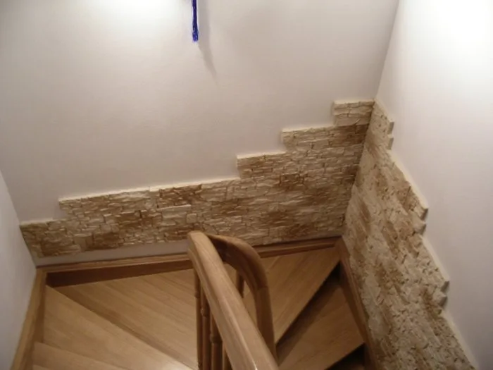Detail dřevěného schodiště s kamennou úpravou zeď