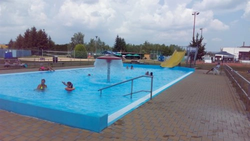 Venkovní bazén v Chropyni s vodnim skluzavkou a fontanou.
