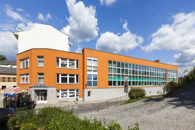 Modrý bazén v Jilemnici s oranžovou budovou.