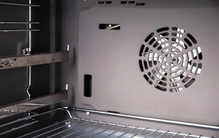 Vnitřek vestavé trouby s ventilátorem pro parní funkci.
