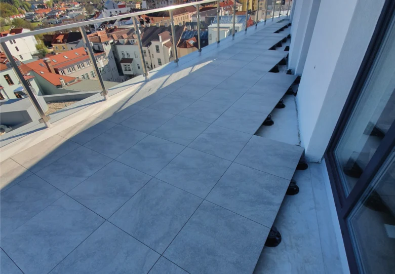 Nově položená dlažba na balkóně s výhledem do města.