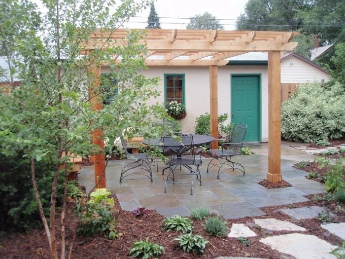 Dokončená dřevěná pergola na zahradním terase s nábytkem.