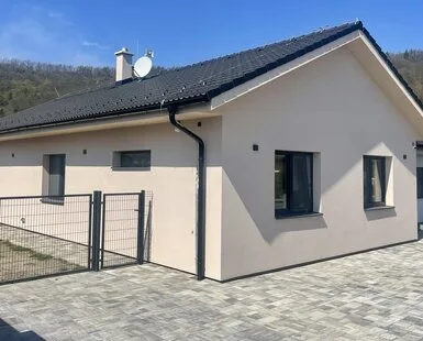 Modern rodinný dům s dlažbou před domem.