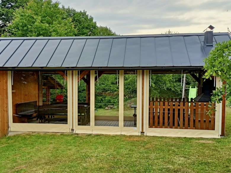 Pergola s plachtou na zahradě v přírodním prostředí.
