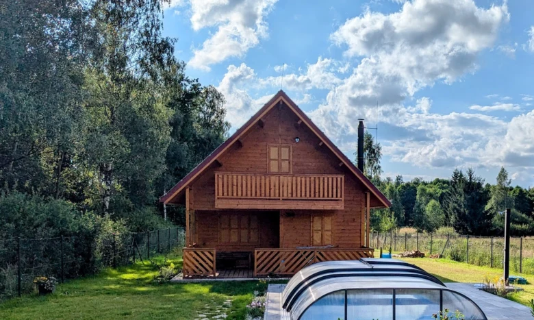 Dřevěná chata s terasou pro celoroční bydlení v přírodě.