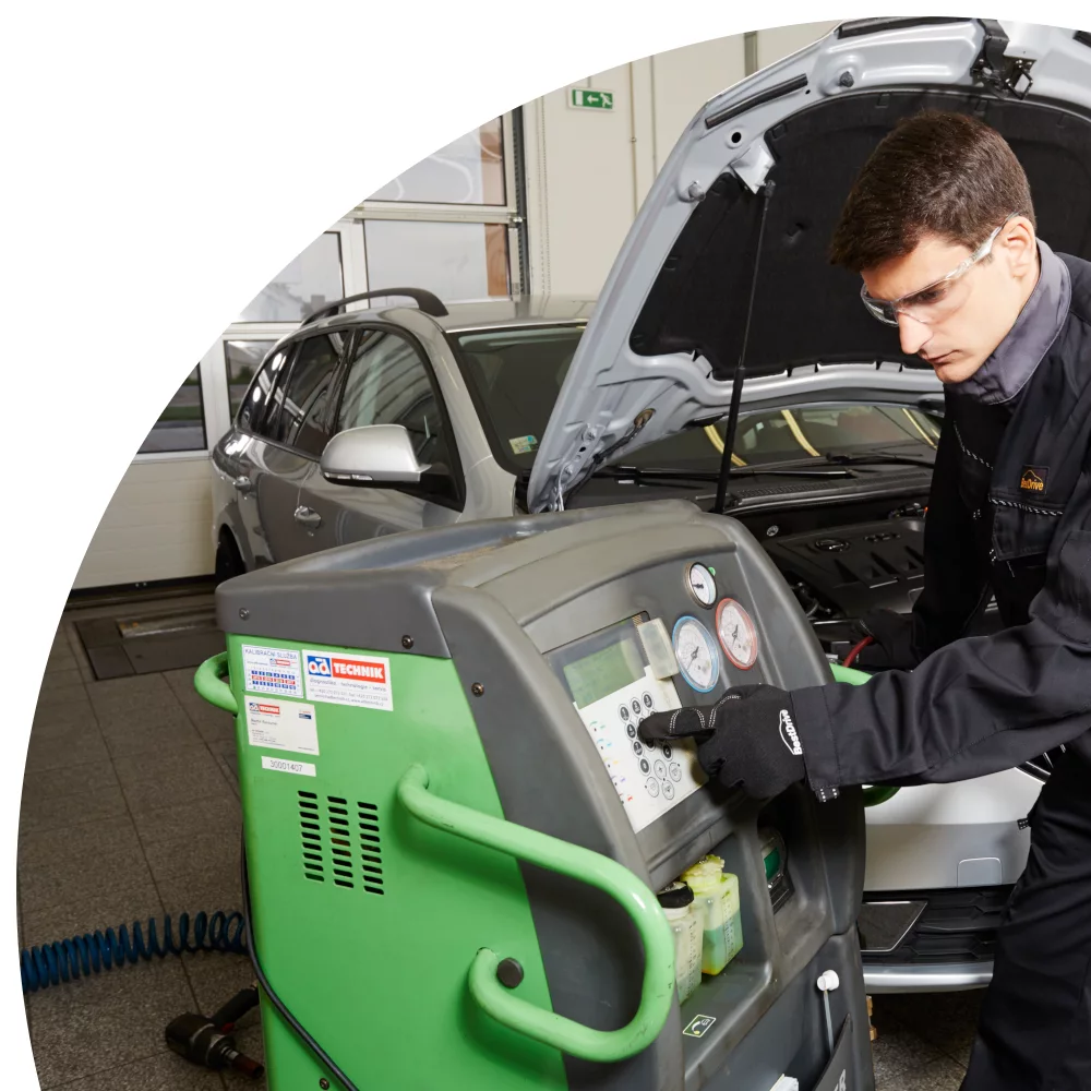 Mechanik opravuje klimatizaci automobilu pomocí specializovaného servisu.