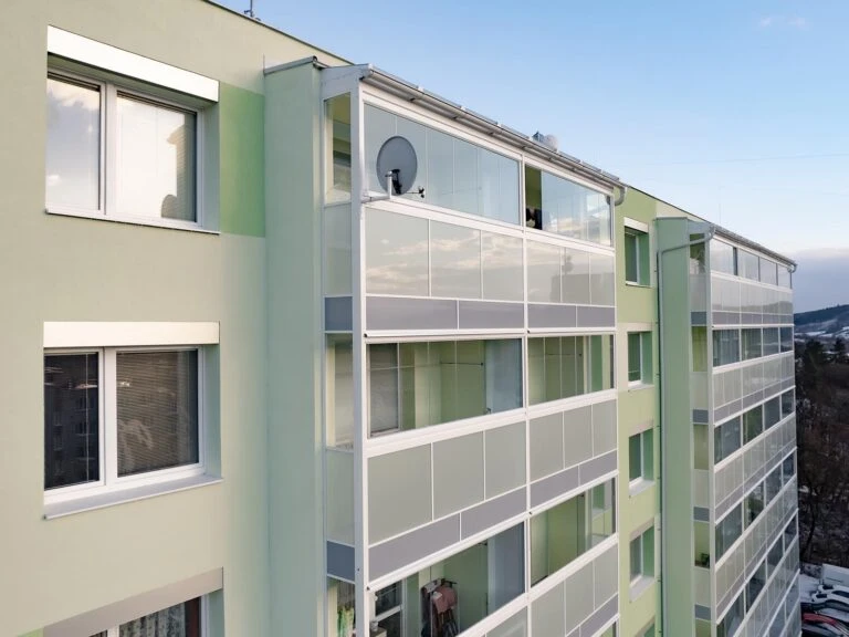 Moderní bytový dům s rekonstruovanými lodžiemi na fasádě.