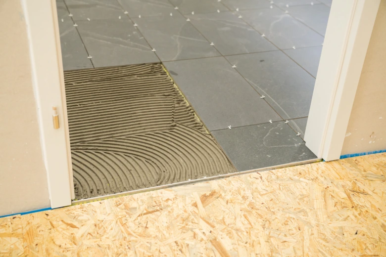 Pohled do místnosti s položenou dlažbou na lepidlo.
