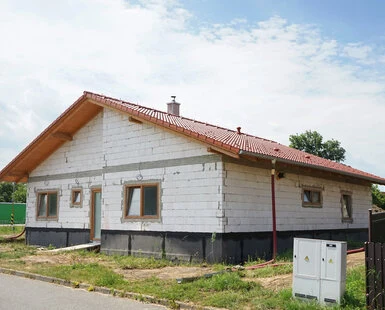 Venkovní zateplená fasáda domu s bílými izolačními deskami.