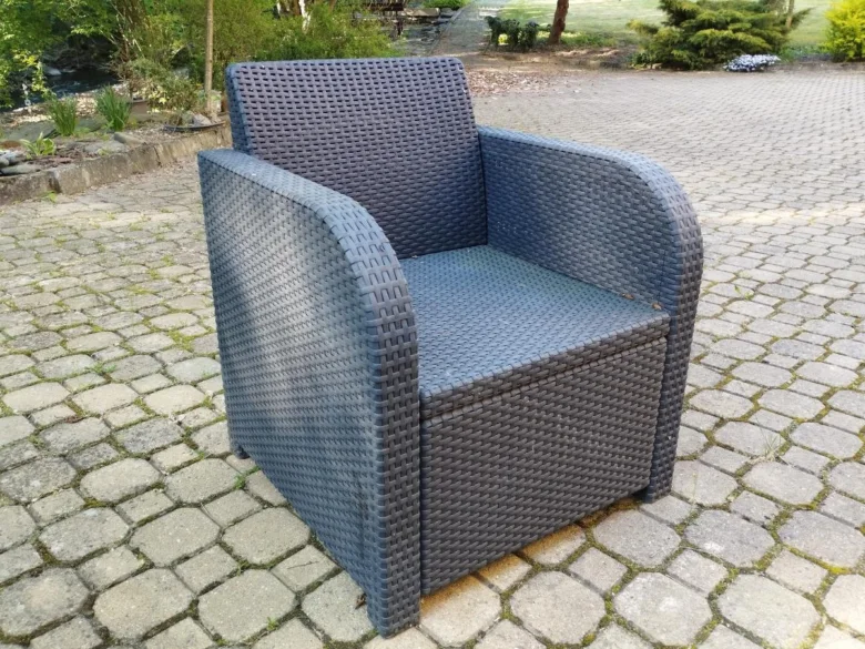 Modré zahradní křeslo z umělého rákosí na dlažbě.