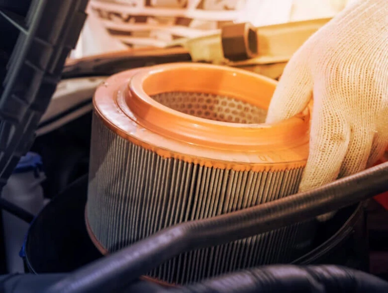 Ruční instalace nového vzduchového filtru do motoru automobilu.