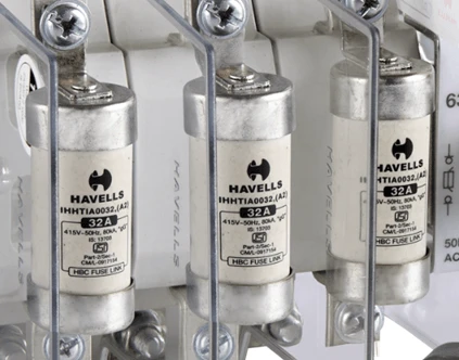 Tři elektrické pojistky značky Havells v držáku na dinovou lištu.