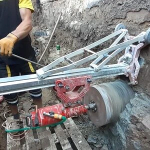 Pracovník používá jádrovák k vrtání vzorku z betonu.