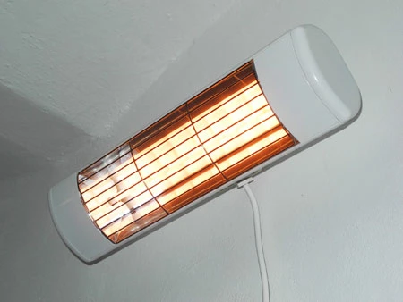Zdi připojený infračervený elektrický topný těleso v interiéru.