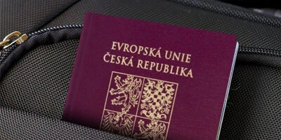 Český pas leží na tmavém povrchu s zipem.