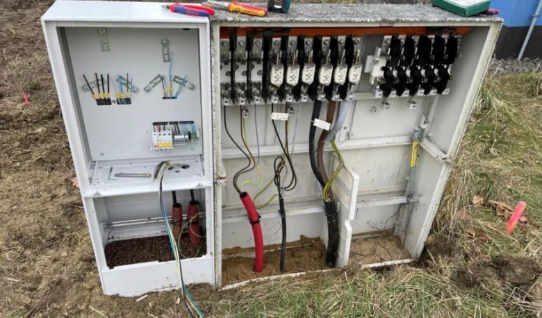 Otevřený elektroměrový rozvaděč s viditelným zapojením a pojistkami.