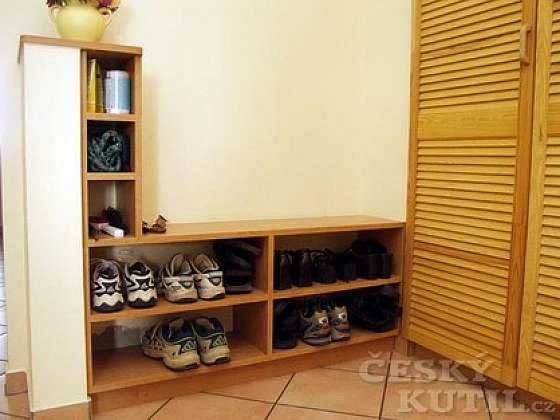 Dřevěný botník s obouváním v interiéru.