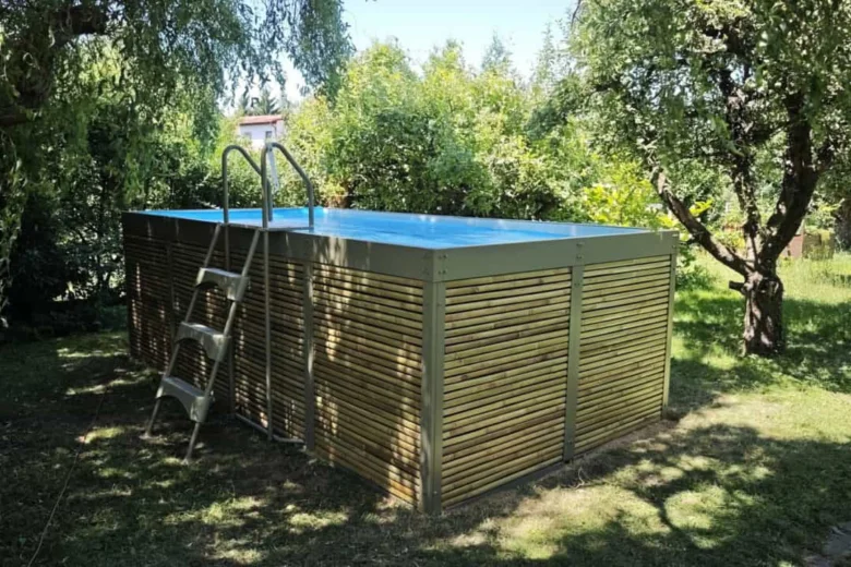 Venkovní bazén s dřevěným obvodem v zahradním prostředí.