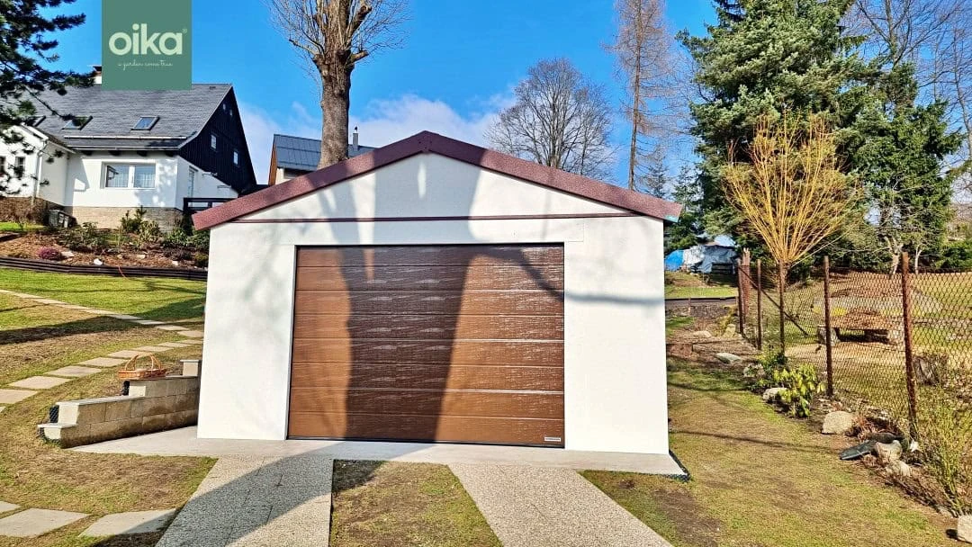 Moderní garáž s dřevěnými dveřmi na pozadí zahradního prostředí.
