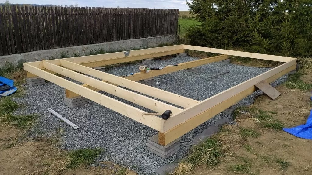 Dřevěný ráz na betonových základních patkách pro dřevostavbu.