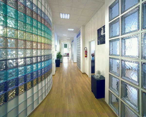 Interiér chodby s instalací barevných skleněných bloků na stěnách.