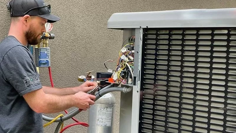 Technik opravuje venkovní jednotku ohřevu vody pro bazén.