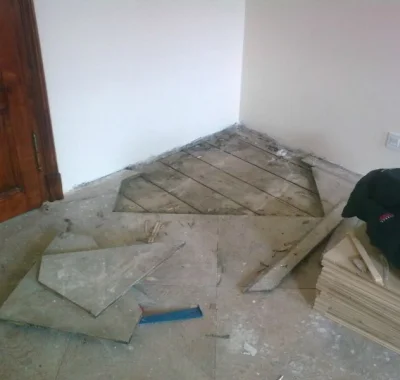 Přestavba podlahy s odstraňováním staré parkety v rohu místnosti.